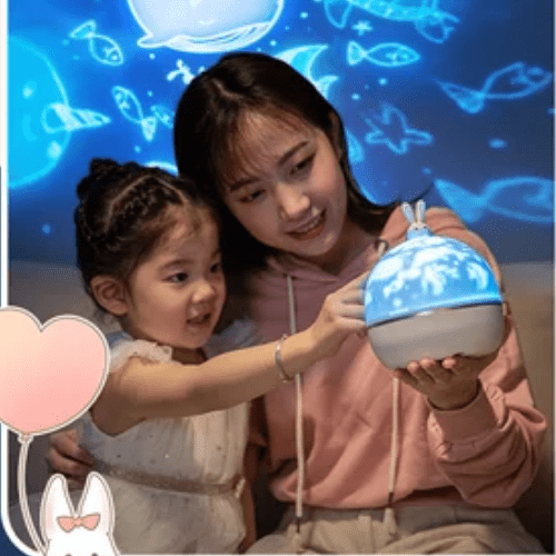 Enfant et mère utilisant projecteur veilleuse rotatif avec projection d'animaux marins bleue dans chambre sombre
