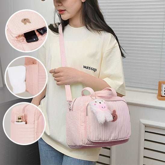 Sac à langer rose motif dessin animé avec multiples poches et bandoulière ajustable, sac pratique et stylé pour parents modernes.